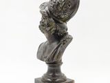 a bronze bust of a woman with a hat on her head