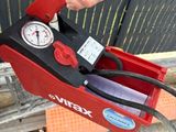 a person holding a red tool box with a gauge