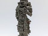 une vieille statue représentant un homme armé d'une épée, sur fond blanc