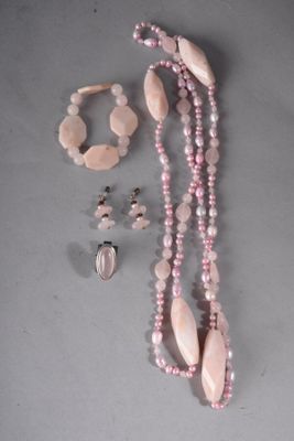 collier, bracelet et bague ornés de perles roses sur un fond gris