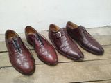 Trois paires de chaussures pour homme sont alignées sur un parquet.