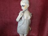 statue of a woman in a dress with a cigarette in her mouth