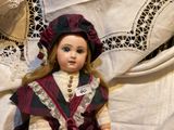 a doll that is sitting on a white sheet