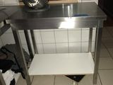 une table en acier inoxydable avec une étagère en dessous, dans une cuisine