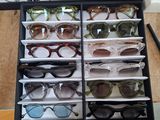 many pairs of sunglasses sitting in a black case