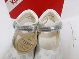 pair of white shoes with silver straps and a red box in the background