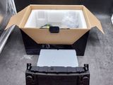 une boîte contenant un ordinateur portable, posée par terre