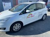 la petite voiture blanche est garée devant un bâtiment