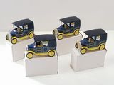 quatre petites voitures jouets bleues et jaunes posées sur des boîtes blanches