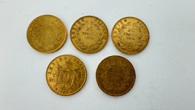 quatre pièces d'or sont disposées en ligne sur une surface blanche