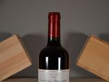 a bottle of wine sitting on a table next to a block of wood