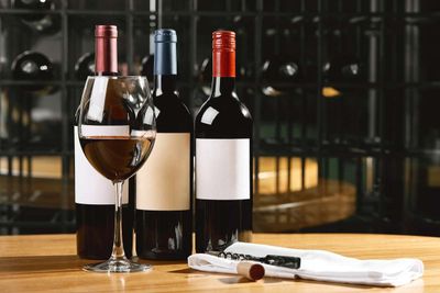 three bottles of wine and two glasses of wine on the table