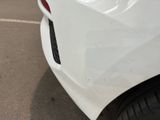 a close up of a white car parked in a parking lot