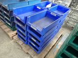 many blue plastic crates stacked on pallets in a warehouse