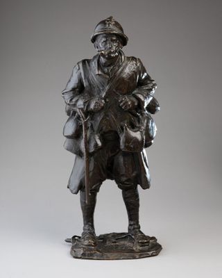 une vieille statue en bronze représentant un homme coiffé d'un chapeau et muni d'une canne