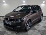 la voiture marron est garée sur un sol en damier dans le garage