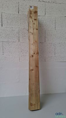 un poteau en bois appuyé contre un mur de briques