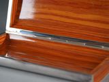 a wooden box with a silver lid on a table