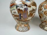 two vases with asian designs on them sitting on a table