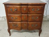 a wooden chest of drawers with brass handles and drawers
