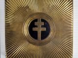 an image of a gold plate with a cross in the center