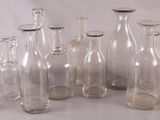 many glass bottles with sand in them on a white surface