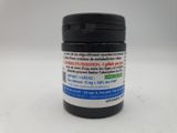 a jar of black and white pills on a white surface