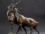 bronze sculpture of a stag on a rock with antelope