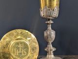 une assiette en or et une coupe en argent posées sur une table