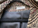 La veste est en laine et possède une doublure en cuir noir