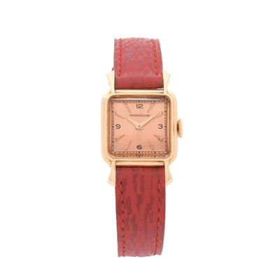 un gros plan d'une montre sur fond blanc, avec un bracelet rouge