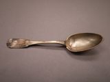 a silver spoon with a spoon handle on a table