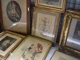 a lot of framed pictures on a table in a room
