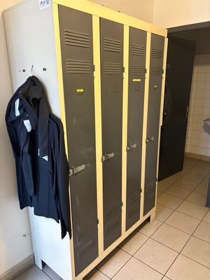 deux casiers dans une salle de bains équipée d'un lavabo et d'un miroir