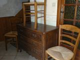une commode en bois et une chaise dans une pièce