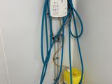 un tuyau bleu fixé au mur, à côté d'un seau jaune