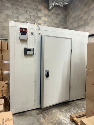une photo d'un congélateur dans un entrepôt, avec des cartons