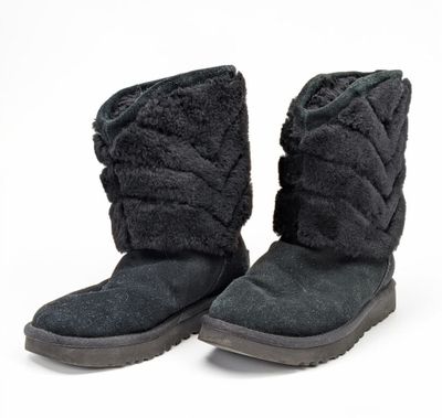une paire de bottes noires pour femme sur fond blanc