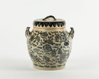 un vase bleu et blanc avec un couvercle posé sur une table