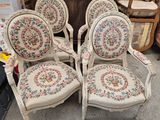four chairs with floral upholstered cushions are sitting in front of a dresser
