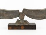 an image of a bronze sculpture of a bird on a wooden base