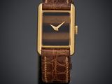 une image représentant une montre avec un bracelet en cuir marron sur fond noir