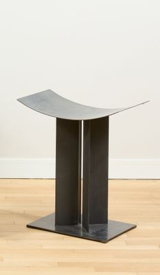 un gros plan sur une table posée sur un parquet, devant un mur blanc