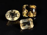 three yellow sapphires on a black surface