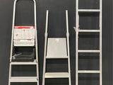 several ladders are lined up against a black wall in a warehouse