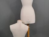 two mannequins on a wooden stand against a gray background