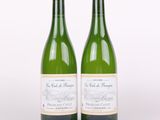 deux bouteilles de vin posées l'une à côté de l'autre sur une surface blanche