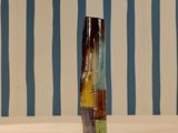 a vase that is sitting on a table in front of a striped wall