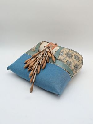 a blue pillow with a bunch of wooden sticks on it