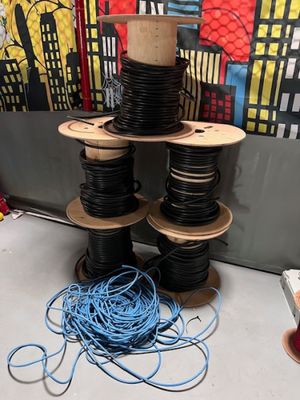 de nombreuses bobines de fils noirs et bleus posées sur une table